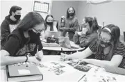  ?? MITCHELL HIGH SCHOOL ?? Yearbook staff members at Mitchell High School in Trinity, Florida, work on page layouts for their 2021 publicatio­n, “Stampede.”