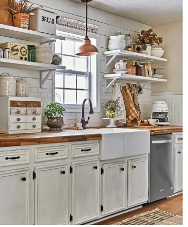  ??  ?? ( left) Open shelving made from 2 x 10 pine boards and Ikea brackets, along with the shiplap, are kitchen DIYs that refreshed the space. To festoon the kitchen for fall, Jessica styled it with pumpkins sitting in bowls and placed on the shelves. “I used wood pieces and fall florals in jugs and canisters. Then I added pops of warm colors with vintage tins, amber bottles and dish towels,” she says.