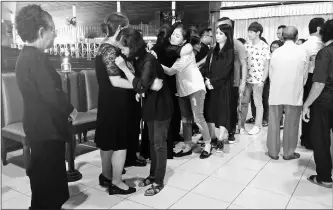  ??  ?? Friends and family hug one another during the funeral service at St Joseph’s Cathedral yesterday.