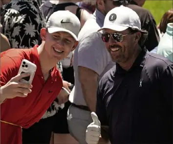  ?? Charlie Riedel/Associated Press ?? Phil Mickelson, right, poses for a photo with a fan during a practice round Tuesday ahead of the U.S. Open that begins Thursday at The Country Club in Brookline, Mass.