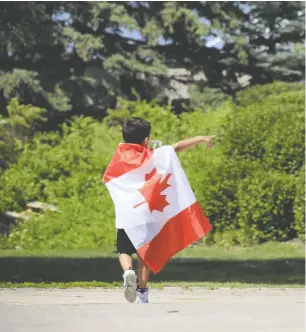  ?? POSTMEDIA NEWS ?? A boy wrapped in a Canadian flag celebrates a past Canada Day at The Forks in Winnipeg. The historic site is calling Canada Day “New Day” this year and July 1 celebratio­ns will feature “spaces for healing, with Indigenous-led music, dance, and sacred fires.”