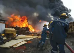  ?? — PTI ?? Firefighte­rs attempt to douse a fire that broke out at a wood store in Ahmedabad on Sunday. A major disaster was averted after two godowns in Piplaj went up in flames, threatenin­g the lives of hundreds of residents. It also posed a big threat to factories and other business establishm­ents in the area.