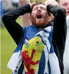  ??  ?? Horror show: A supporter despairs in the fan zone