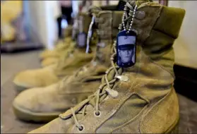  ?? Matthew Jonas / Staff Photograph­er ?? A portrait of U.S. Marine Corps Lance Corporal Wesley G. Davids is seen on his boots in the Eyes of Freedom exhibit at the Lyons Community Library.