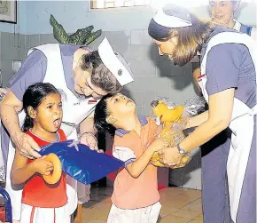  ??  ?? Las Damas Grises entregan regalos a los niños del Centro de Rehabilita­ción de la Cruz Roja Seccional Atlántico, en el 2006.