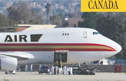  ?? MIKE BLAKE / REUTERS ?? Personnel in protective clothing at March Air Reserve Base in Riverside County, Calif., approach an aircraft Wednesday that was chartered by the U.S. State Department to evacuate Americans from the central Chinese city of Wuhan, which is at the centre of the coronaviru­s outbreak.