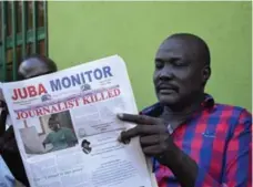  ?? AFP/GETTY IMAGES ?? A man reads the Juba Monitor, with a front-page story on the killing of South Sudanese reporter Peter Moi of The New Nation newspaper.