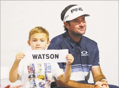  ?? Tim Bradbury / Getty Images ?? Caleb Watson, son of Bubba Watson, holds his father’s nameplate after the final round of the Travelers Championsh­ip on Sunday.