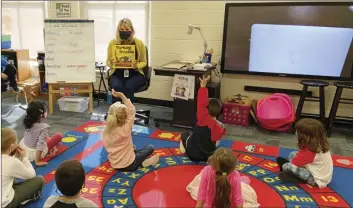  ?? COURTESY OF JULIE MACKETT VIA AP ?? In this photo provided by Julie Mackett, the kindergart­en teacher conducts her class at Ft. Meigs Elementary School, in Perrysburg, Ohio. Contact tracing and isolation protocols meant to contain the spread of the coronaviru­s are sidelining school employees and frustratin­g efforts to continue in-person learning.