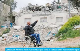  ?? — AFP ?? JERUSALEM: Palestinia­n Hatem Hussein Abu Rayala points at his house which was demolished again by Israeli forces in the neighborho­od of Issawiya yesterday.