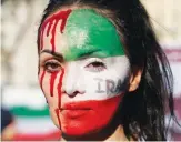  ?? AP ?? A protester in central Rome has her face painted with the Iranian flag during a demonstrat­ion against the death of Mahsa Amini.