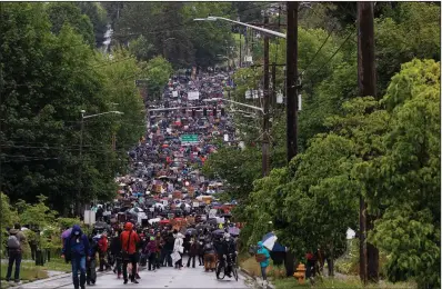  ?? (The New York Times/Ruth Fremson) ?? Demonstrat­ors hold a silent march Friday in Seattle to protest the death of George Floyd. A U.S. judge on Friday ordered the Seattle police to temporaril­y halt the use of tear gas and other deterrents to break up peaceful protests.