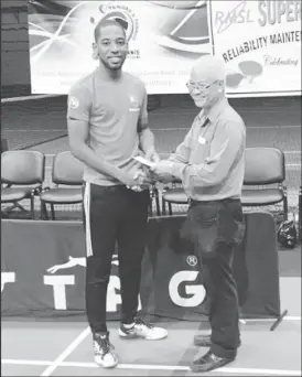  ??  ?? Guyanese Shemar Britton received his earnings after copping another T&amp;T table tennis title