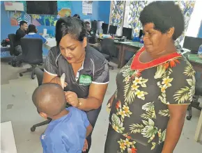  ??  ?? Members of the Frank Hilton audiology team examine young students’ hearing abilities.