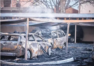  ?? ROBERTO E. ROSALES/JOURNAL ?? The charred remains of dozens of vehicles were still smoldering Friday morning following a fire at an apartment parking lot in Southeast Albuquerqu­e. Close to 60 vehicles were burned, according to the fire department. Nobody was injured, and the cause...