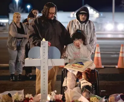  ?? CHET STRANGE/GETTY IMAGES ?? Richard Fierro consoles his daughter, Kassandra, as she signs a plaque to her slain boyfriend on Tuesday at a memorial outside of Club Q in Colorado Springs, Colorado. Fierro is credited with subduing the gunman who killed five people.