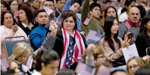  ?? Reuters ?? People wave US flags during a naturalisa­tion ceremony at the Los Angeles Convention Centre in Los Angeles. —