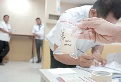  ?? SUNSTAR FOTO / ALEX BADAYOS ?? DRUG TEST. A driver signs papers during a random drug test at the Cebu South Bus Terminal.