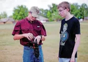  ??  ?? Thomas Kilpatrick, left, pours water into a model rocket alongside Gage Cutler during a summer academy at Oklahoma Christian University.