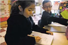  ??  ?? Niza Cerda and a classmate work Nov. 19 on drawing diagrams of how wind moves bubbles as part of a science experiment in Rita Rios-Baca’s first-grade class at Ramirez Thomas Elementary School.