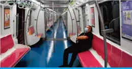  ?? — AFP ?? BEIJING: A man wearing a face mask sits in a subway train on Saturday.