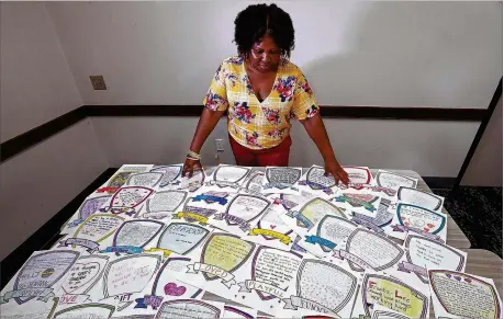  ?? CURTIS COMPTON/CCOMPTON@AJC.COM ?? Suicide survivor Doris Adhuze, a mom whose 13-year-old son Jovany hanged himself last year, looks over dozens of notes from his classmates and teachers earlier this month in Decatur.