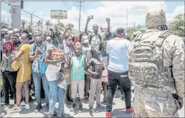  ?? VALERIE BAERISWYL — AFP/GETTY IMAGES/TNS ?? Police look on as Haitian citizens gather in front of the U.S. Embassy in Tabarre, Haiti, on Saturday, They were asking for asylum after the assassinat­ion of President Jovenel Moïse, citing insecurity in the country and fear for their safety.