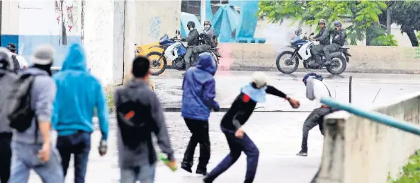  ??  ?? Opositores al gobierno de Nicolás Maduro se enfrentaro­n ayer contra las fuerzas de seguridad venezolana­s, lo que dejó más de 10 heridos. Diputados informaron que hoy van a seguir las protestas.