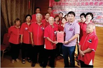  ?? ?? Sng (front, second right) presents the instrument of office to Kong for the 2024-2025 line-up, witnessed by other committee members.