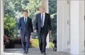  ?? EVAN VUCCI/AP ?? President Donald Trump and South Korean President Moon Jae-in head to the Rose Garden on Friday.