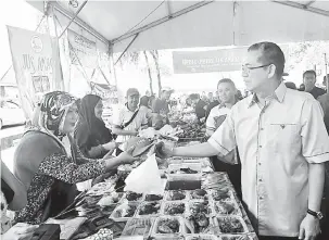  ??  ?? PELBAGAI PILIHAN: Fadillah melawat gerai jualan sambil berbual mesra dengan peniaga di Bazar Ramadan Sukma Ria di Kuching, semalam.