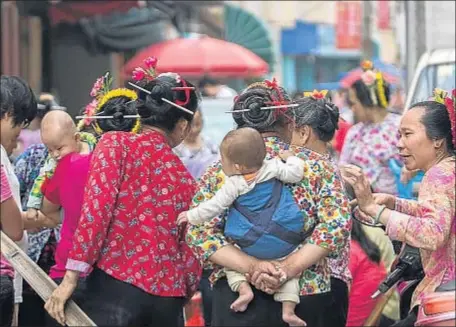  ?? ZHANG PENG / GETTY ?? Mujeres de la población china de Xunpu, con unos bebés en el mercado de pescado