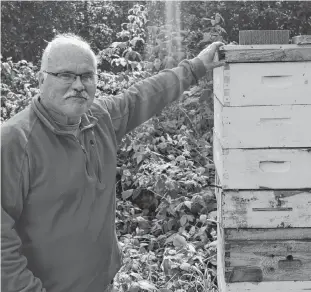 ?? DAVE STEWART/THE GUARDIAN ?? Bruce Smith, a beekeeper in Morell, says not only are bees vital to the environmen­t they are not aggressive and nothing to be afraid of. This hive alone contains more than 60,000 bees. During the interview with Smith at this beehive (there are additional hives next to the one pictured here) hundreds of bees flew in and out of the hives, not once bothering him or this reporter.
