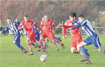  ?? Pic: ANTHONY WARD ?? Asa Thomas challenges for Holyhead (stripes) as team-mate Gavin Sharpe looks on against Buckley Town in the Huws Gray Cup