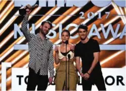  ??  ?? Alex Pall, left, and Andrew Taggart, right, of The Chainsmoke­rs, and Halsey accept the award for Top Collaborat­ion for ‘Closer’.