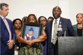  ?? GERALD HERBERT / AP ?? Chantemekk­i Fortson, mother of Roger Fortson, a U.S. Air Force senior airman, holds a photo of her son during a news conference about his death, along with family and attorney Ben Crump (right) and Brian Bar (left) in Fort Walton Beach, Fla., on Thursday. Fortson was shot and killed by police in his apartment May 3.