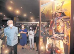  ??  ?? Deputy Prime Minister and Foreign Minister Don Pramudwina­i looks at samurai armour at a museum in the Japanese settlement in Ayutthaya. Deer skin was among export goods used as a cushion in samurai armour.