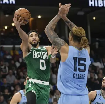  ?? BRANDON DILL — THE ASSOCIATED PRESS ?? Boston Celtics forward Jayson Tatum (0) shoots against Memphis Grizzlies forward Brandon Clarke during the first half Monday night.