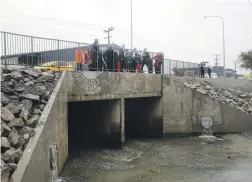  ?? MARTIN DE RUYTERSTUF­F/ ?? Officials gather at the headwall of the Saxton Creek culvert, part of the final stage of a $40 million flood protection project.