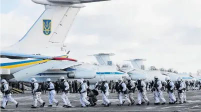  ?? PHOTO: REUTERS ?? On a mission . . . Ukrainian paratroope­rs prepare to board military planes before departing to the eastern regions of the country at an air force base near Zhytomyr, Ukraine, yesterday.