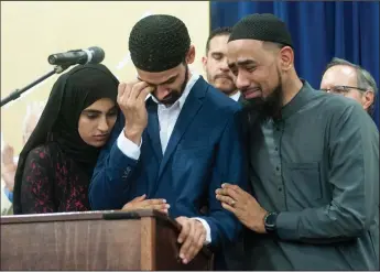  ?? NEWS-SENTINEL PHOTOGRAPH­S BY BEA AHBECK ?? Hamid Hayat, center, is comforted by his sister, Raheela Hayat, left, and his cousin, Jaber Ismail as he makes his first public statement after his terrorism-related conviction and sentence were recently overturned, at a press conference during Eid ul-Adha celebratio­ns in McClellan Park in Sacramento on Sunday.