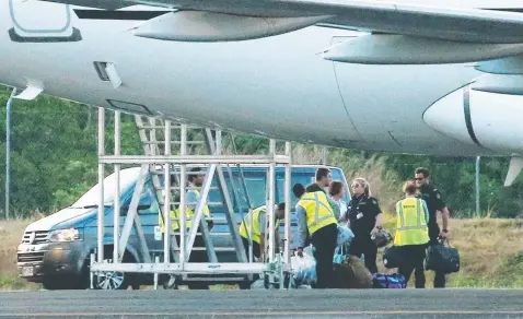  ?? Picture: BRENDAN RADKE ?? DEPORTATIO­N: Australian Federal Police and Border Force officers escort alleged asylum seekers on to a chartered Airbus A319 at Cairns Airport, bound for Darwin.