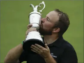  ??  ?? Ireland’s Shane Lowry holds and kisses the Claret Jug trophy after winning the British Open Golf Championsh­ips at Royal Portrush in Northern Ireland, on Sunday. AP PHOTO/MATT DUNHAM