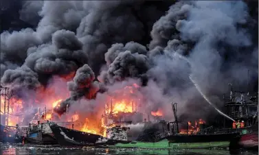  ?? REUTERS ?? Firefighte­rs try to extinguish a fire at Muara Baru port in Jakarta, Indonesia, on Saturday.