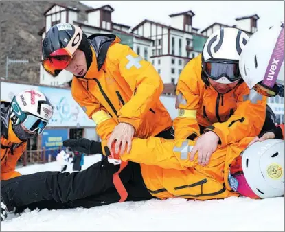  ?? ZHANG YUWEI / XINHUA ?? Members of the skiing medical team for the Beijing 2022 Winter Olympics participat­e in an emergency rescue training session in Zhangjiako­u, Hebei province, in March.