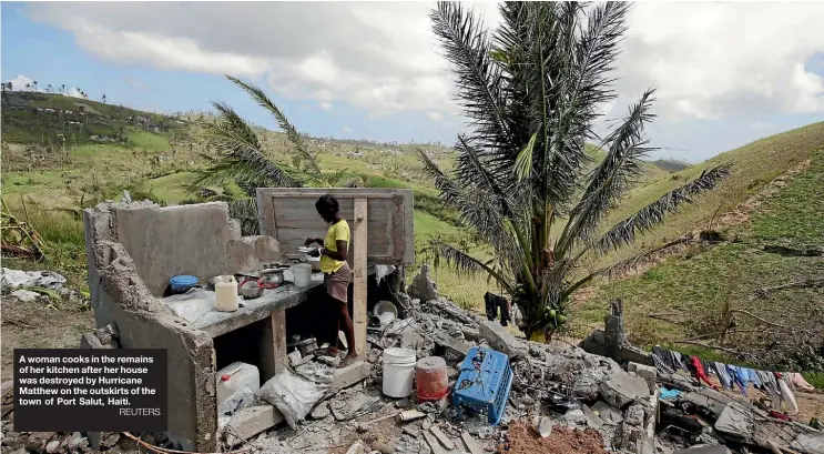  ??  ?? A woman cooks in the remains of her kitchen after her house was destroyed by Hurricane Matthew on the outskirts of the town of Port Salut, Haiti.