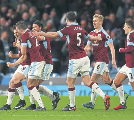  ??  ?? MAN OF THE MOMENT: Joey Barton is congratula­ted by George Boyd and his other Burnley teammates after scoring.