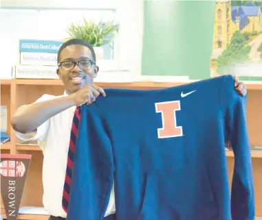  ?? JEFF VORVA/DAILY SOUTHTOWN ?? Deontae Farrow of Richton Park holds up a University of Illinois hoodie. The Southland College Prep senior has overcome multiple sclerosis to excel in the classroom and to return to cross country and track. He is heading to U of I in the fall.