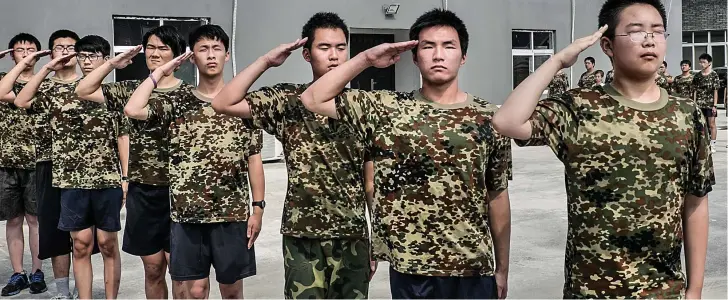  ??  ?? Smart salute: At the Daxing Internet Addiction Treatment Centre, it’s time to put down that mouse, pull on a camouflage T-shirt and learn to click heels, not screen icons