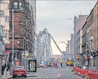  ??  ?? Firefighte­rs continue to dampen ruined buildings in Sauchiehal­l Street yesterday